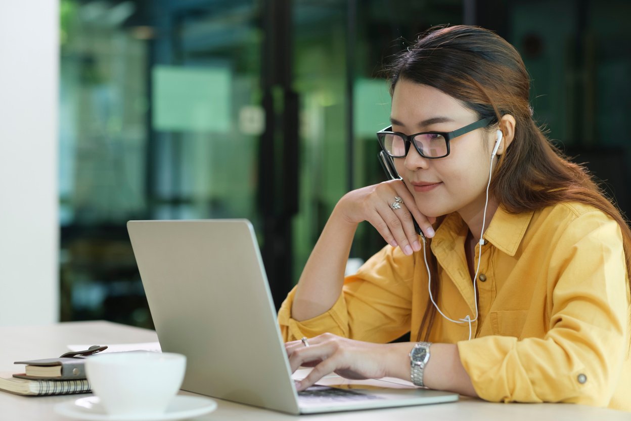 Digital Learning: Woman Wearing Headphones Engaged in Online Education